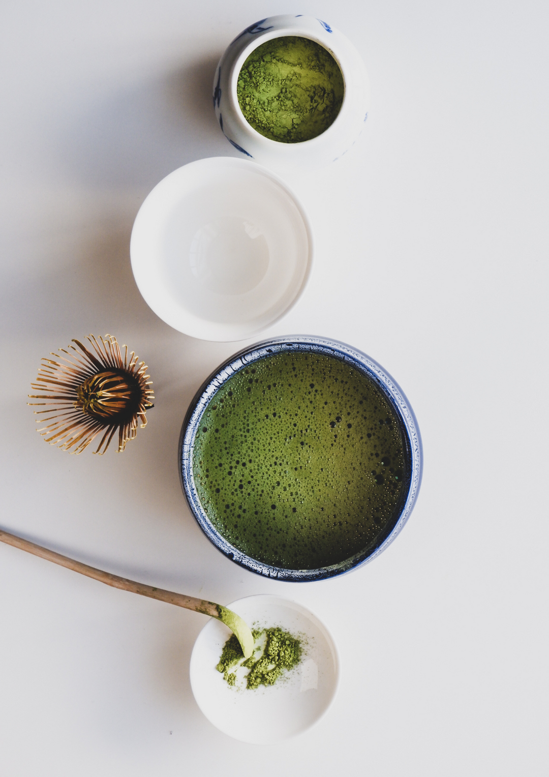 Traditional Japanese matcha green tea ceremony with a bamboo whisk and tea bowl.
